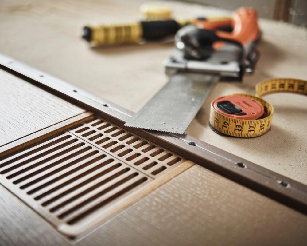 Piła i miarka w trakcie pracy nad drzwiami