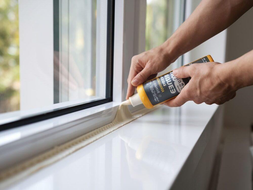 Plastikowe okno podczas uszczelniania